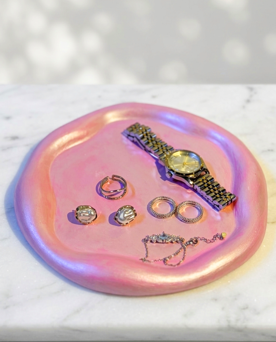 Close-up of RocioTreasure pink tray styled with jewelry and a wristwatch.